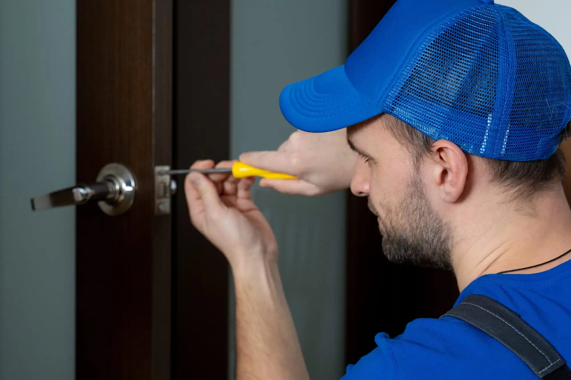 Locksmith servicing a door latch and strike plate in Charlotte, NC
